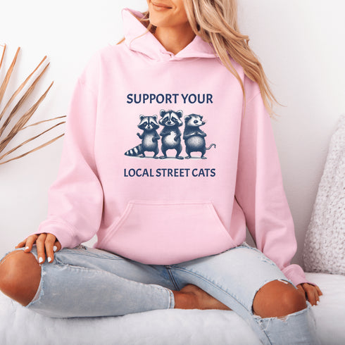 Nothing says “community support” like two raccoons and a possum banding together for the greater good (or maybe just snacks).